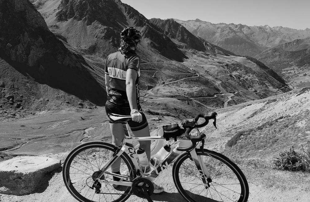 Black and white image of a woman cycling looking over a mountainous landscape in Spain 